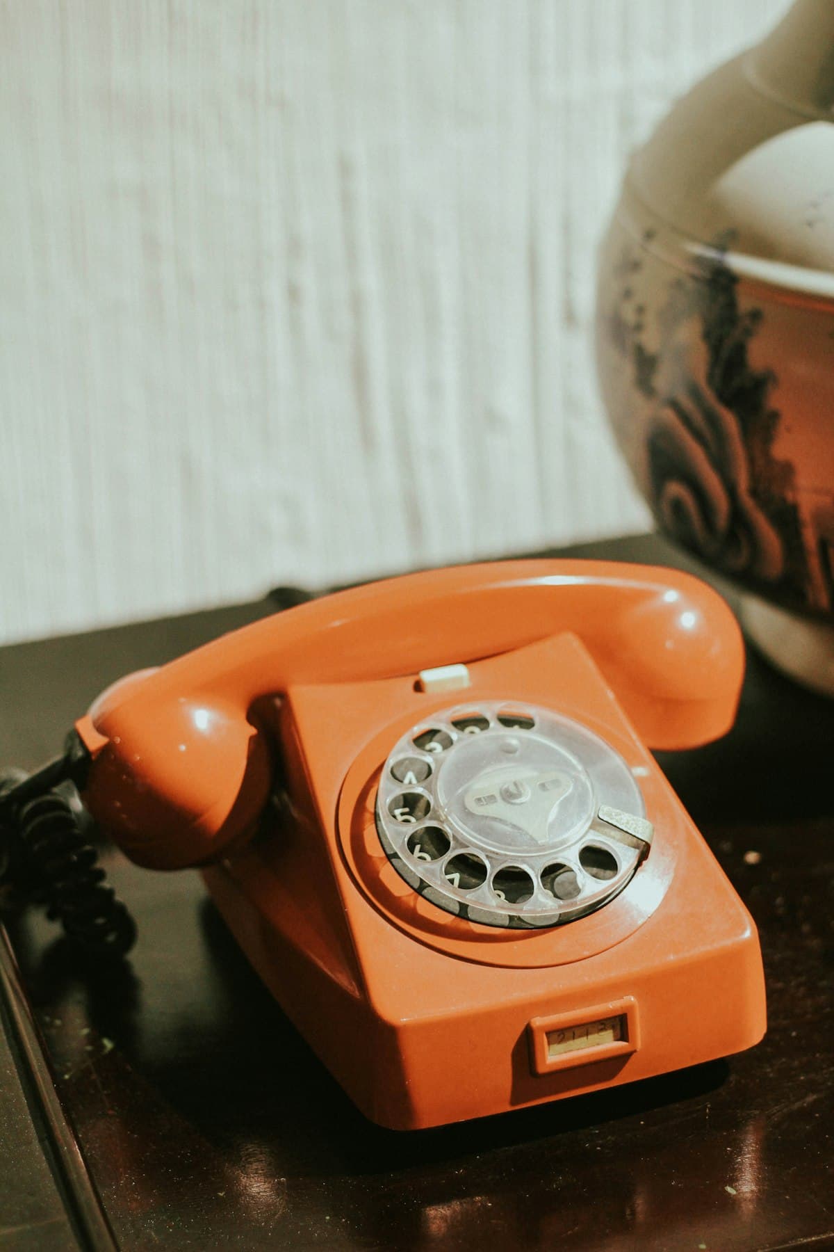 Červený tlačítkový telefon na dřevěném stole